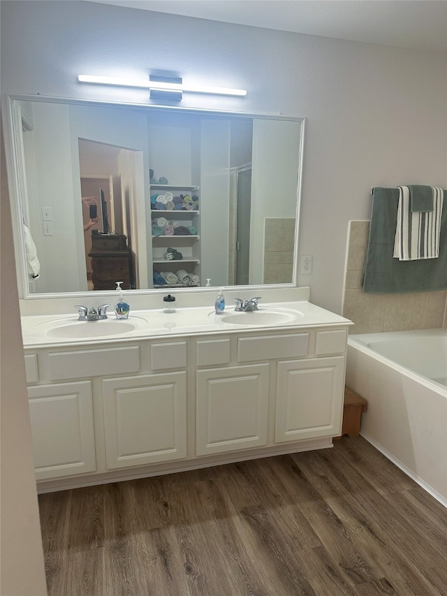 12107 English Brook Cir, Humble, TX 77346 - bathroom with double vanity, wood finished floors, a garden tub, and a shower