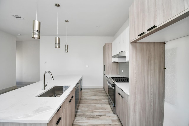 4016 Boho Ln, Houston, TX 77045 - kitchen with appliances with stainless steel finishes, modern cabinets, a sink, an island with sink, and light brown cabinetry