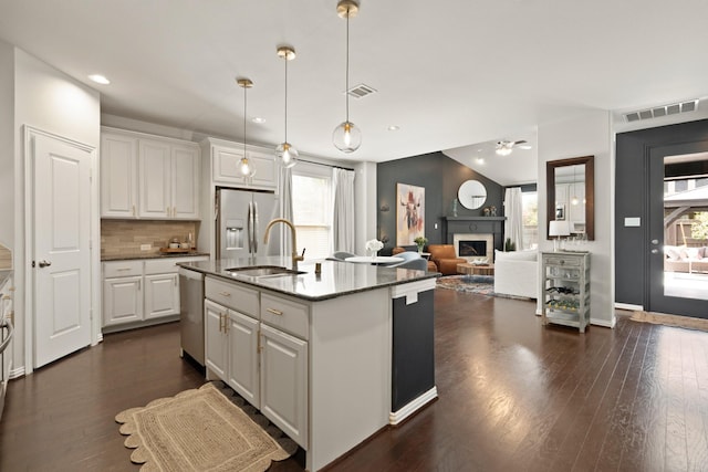 3638 Long Flower Ct, Fulshear, TX 77441 - kitchen featuring appliances with stainless steel finishes, a sink, a fireplace, white cabinetry, and ceiling fan