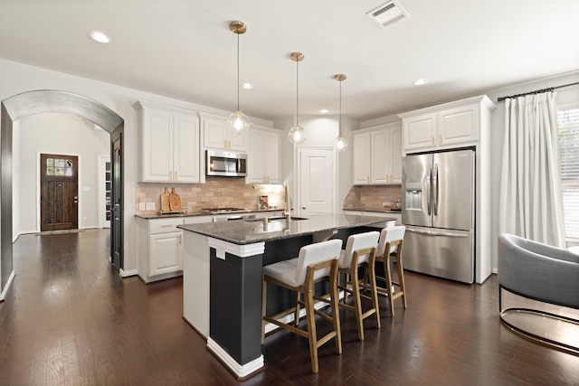 3638 Long Flower Ct, Fulshear, TX 77441 - kitchen with stainless steel appliances, white cabinetry, dark wood-type flooring, decorative backsplash, and recessed lighting