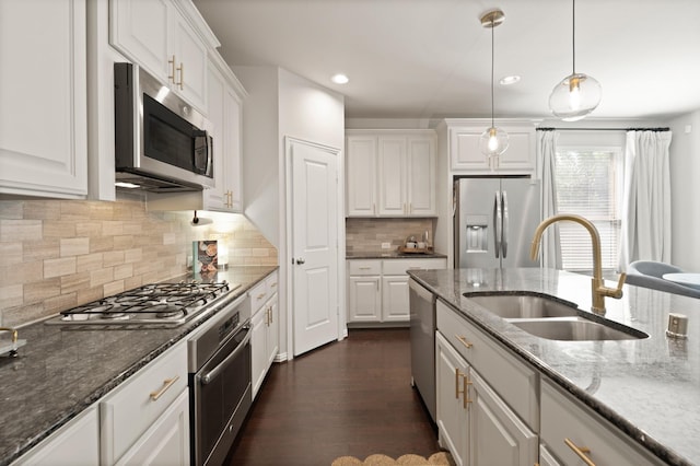 3638 Long Flower Ct, Fulshear, TX 77441 - kitchen with stainless steel appliances, a sink, white cabinets, dark stone counters, and pendant lighting