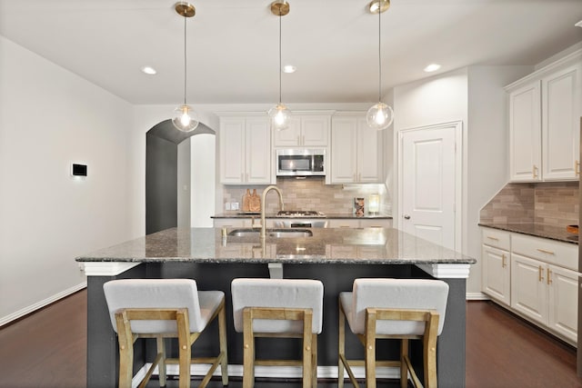 3638 Long Flower Ct, Fulshear, TX 77441 - kitchen featuring stainless steel microwave, a sink, backsplash, dark wood-type flooring, and recessed lighting