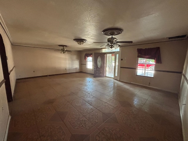 1205 14th St, Seagraves, TX 79359 - tiled empty room with ceiling fan, baseboards, and a textured ceiling