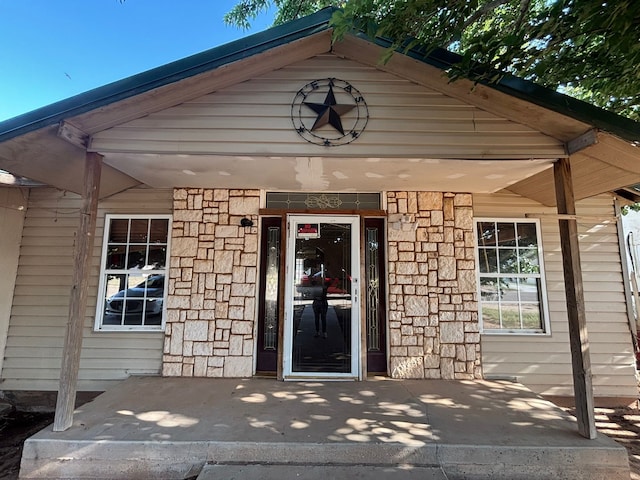 1205 14th St, Seagraves, TX 79359 - view of exterior entry with stone siding and covered porch