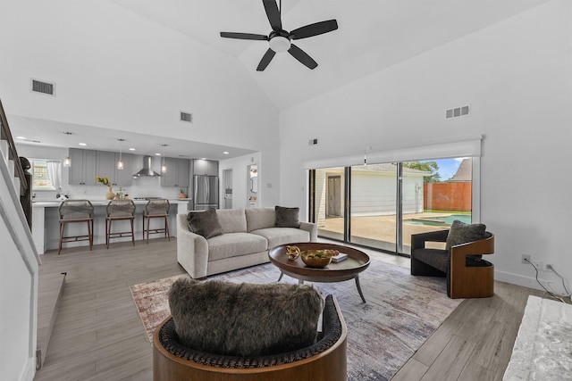1323 Warwickshire Dr, Houston, TX 77077 - living area with high vaulted ceiling, light wood-type flooring, a ceiling fan, and baseboards