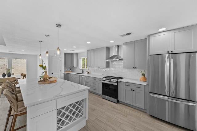 1323 Warwickshire Dr, Houston, TX 77077 - kitchen featuring appliances with stainless steel finishes, gray cabinets, wall chimney range hood, a sink, and recessed lighting