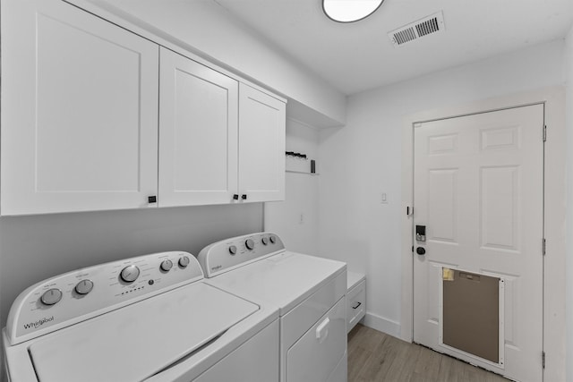 1323 Warwickshire Dr, Houston, TX 77077 - laundry room featuring independent washer and dryer, cabinet space, and light wood-style floors