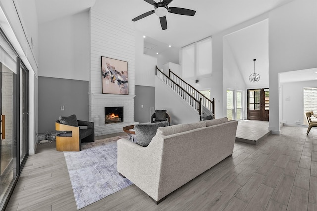1323 Warwickshire Dr, Houston, TX 77077 - living room featuring a brick fireplace, high vaulted ceiling, ceiling fan, wood finished floors, and stairway