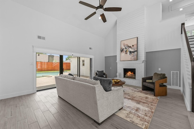 1323 Warwickshire Dr, Houston, TX 77077 - living area with high vaulted ceiling, a ceiling fan, a fireplace, healthy amount of natural light, and stairs