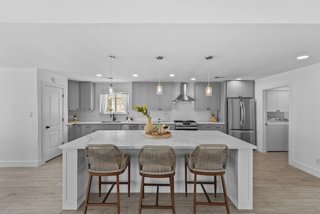 1323 Warwickshire Dr, Houston, TX 77077 - kitchen featuring gray cabinetry, washer / dryer, stainless steel appliances, wall chimney range hood, and recessed lighting