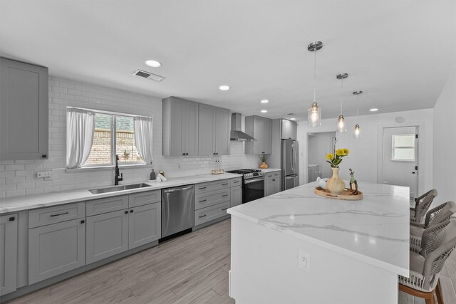 1323 Warwickshire Dr, Houston, TX 77077 - kitchen with appliances with stainless steel finishes, gray cabinets, a sink, wall chimney range hood, and recessed lighting