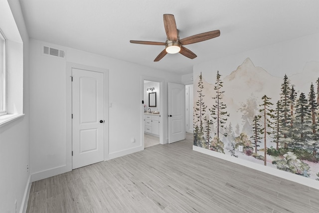 1323 Warwickshire Dr, Houston, TX 77077 - unfurnished bedroom featuring light wood-type flooring, baseboards, ensuite bath, and ceiling fan