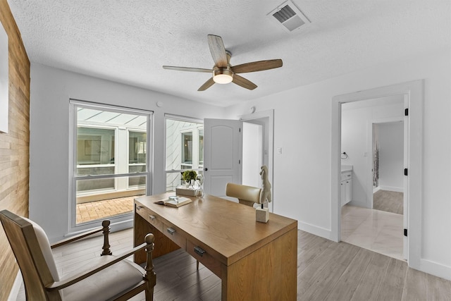 1323 Warwickshire Dr, Houston, TX 77077 - office with ceiling fan, light wood-style floors, a textured ceiling, and baseboards