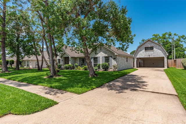 811 Hackberry Ln, Friendswood, TX 77546 - view of front of house with a detached garage, an outbuilding, driveway, and stone siding