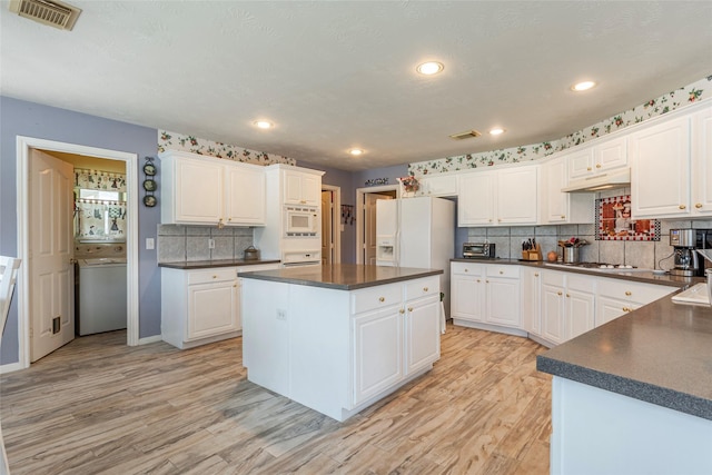 811 Hackberry Ln, Friendswood, TX 77546 - kitchen featuring dark countertops, light wood-type flooring, white appliances, decorative backsplash, and recessed lighting