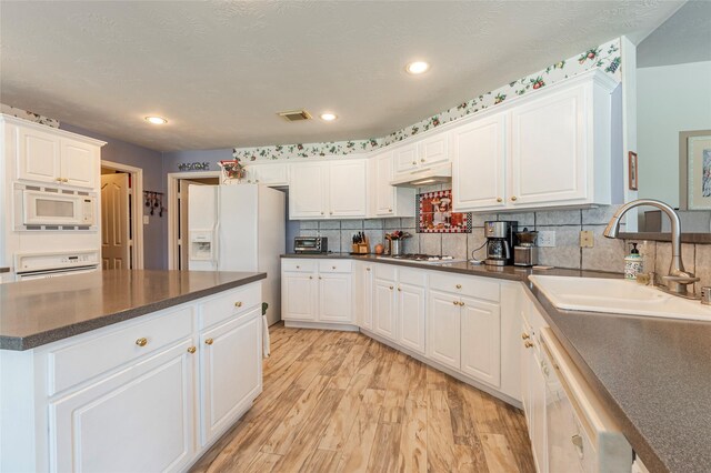 811 Hackberry Ln, Friendswood, TX 77546 - kitchen featuring white appliances, a sink, dark countertops, white cabinetry, and light wood finished floors