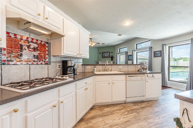 811 Hackberry Ln, Friendswood, TX 77546 - kitchen featuring white appliances, a sink, backsplash, white cabinets, and a peninsula