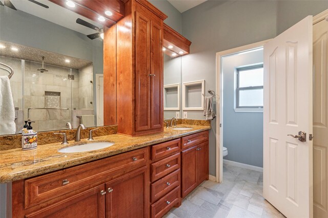 811 Hackberry Ln, Friendswood, TX 77546 - bathroom with ceiling fan, a shower stall, double vanity, baseboards, and toilet