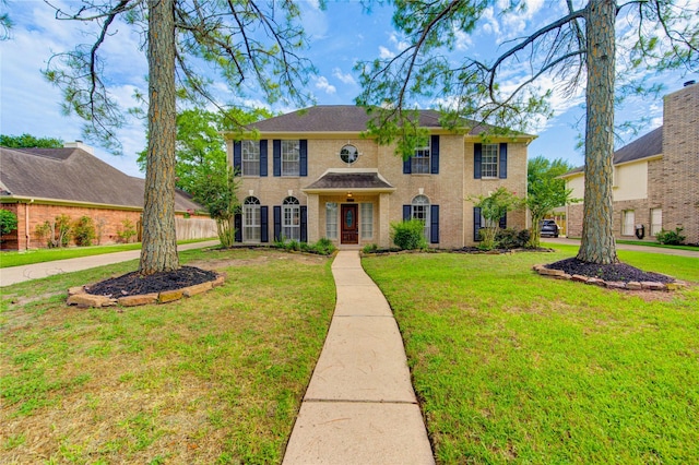 14823 Atterbury Dr, Sugar Land, TX 77498 - colonial inspired home with a front yard and brick siding