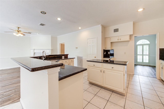 14823 Atterbury Dr, Sugar Land, TX 77498 - kitchen featuring a spacious island, a sink, a ceiling fan, recessed lighting, and light tile patterned flooring