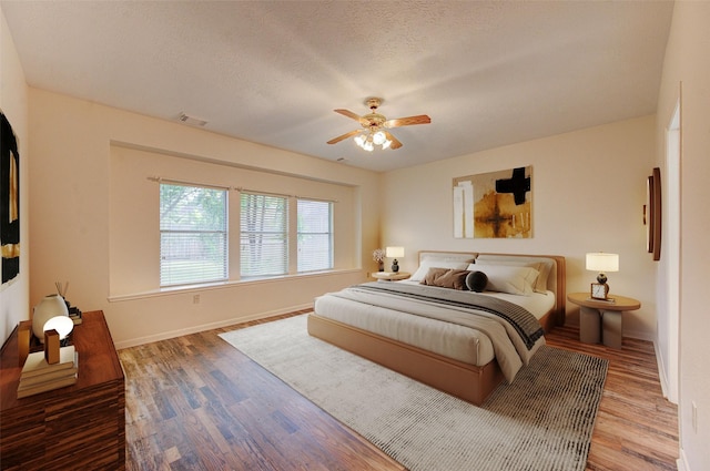14823 Atterbury Dr, Sugar Land, TX 77498 - bedroom with wood finished floors, baseboards, a ceiling fan, and a textured ceiling