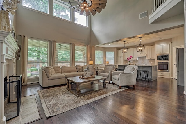 15 Watermint Pl, The Woodlands, TX 77384 - living area featuring a towering ceiling, healthy amount of natural light, dark wood finished floors, a ceiling fan, and recessed lighting