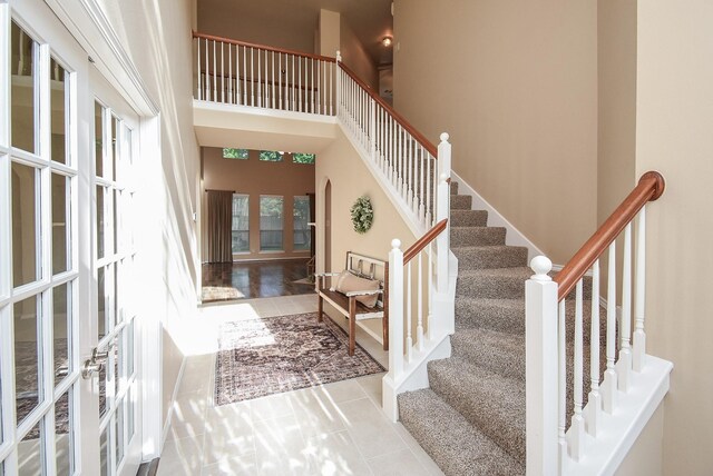 2803 Lakecrest Way Dr, Katy, TX 77493 - entrance foyer with stairway, tile patterned floors, french doors, and a towering ceiling