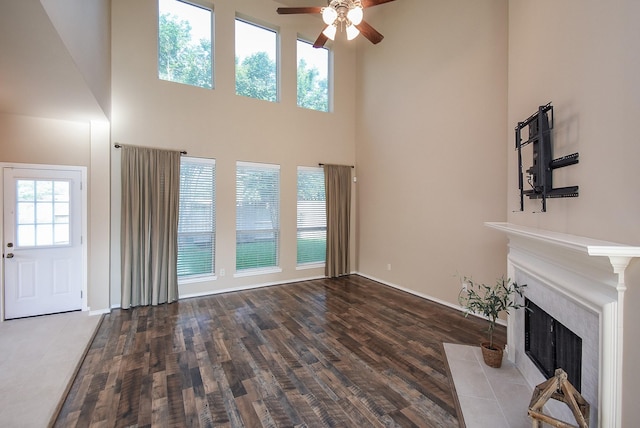 2803 Lakecrest Way Dr, Katy, TX 77493 - unfurnished living room featuring a ceiling fan, a fireplace with flush hearth, wood finished floors, a high ceiling, and baseboards