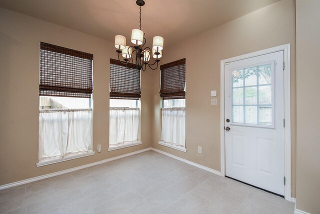 2803 Lakecrest Way Dr, Katy, TX 77493 - unfurnished dining area with a chandelier, light tile patterned floors, and baseboards