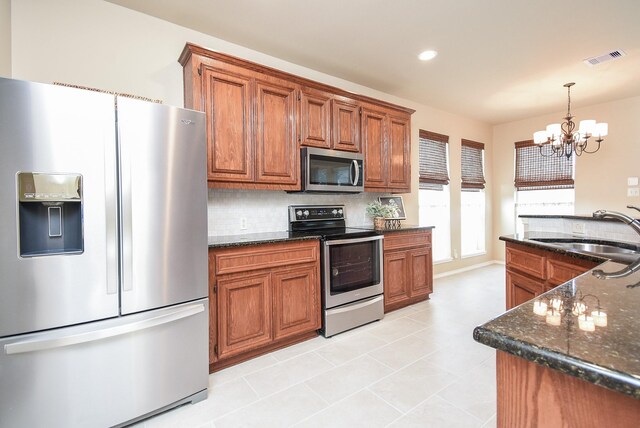 2803 Lakecrest Way Dr, Katy, TX 77493 - kitchen with appliances with stainless steel finishes, a sink, a chandelier, brown cabinetry, and recessed lighting