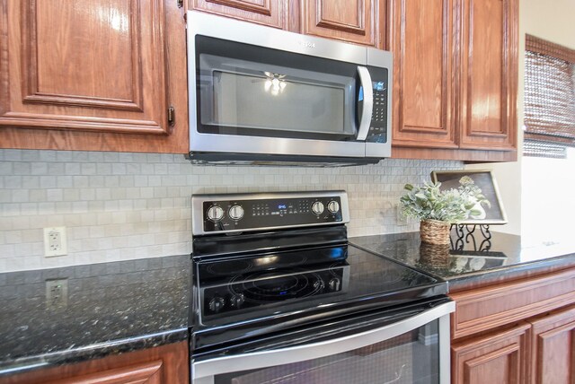 2803 Lakecrest Way Dr, Katy, TX 77493 - kitchen with stainless steel microwave, electric range, decorative backsplash, and brown cabinetry