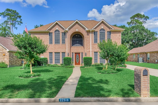 22918 Ammick Ct, Spring, TX 77389 - view of front facade with a front yard, cooling unit, and brick siding