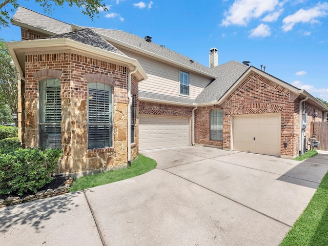 12118 Pinelands Park Ln, Humble, TX 77346 - view of front of property with a shingled roof, concrete driveway, brick siding, a chimney, and an attached garage