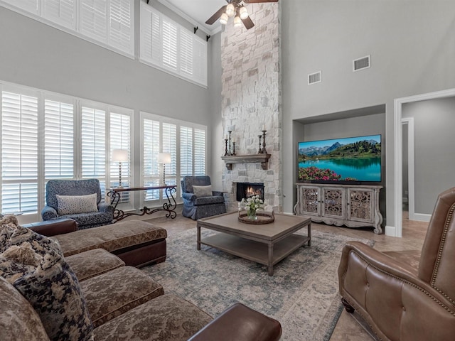 12118 Pinelands Park Ln, Humble, TX 77346 - living room featuring a towering ceiling, healthy amount of natural light, ceiling fan, and a stone fireplace