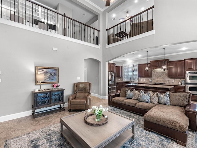 12118 Pinelands Park Ln, Humble, TX 77346 - living area featuring arched walkways, ornamental molding, a ceiling fan, and a towering ceiling