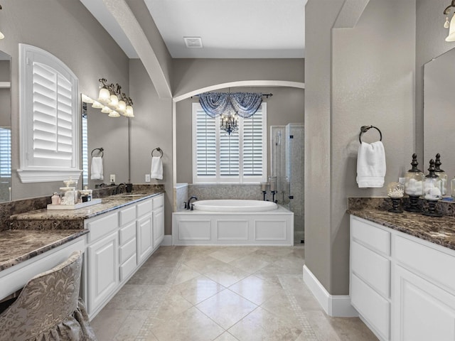 12118 Pinelands Park Ln, Humble, TX 77346 - bathroom with a chandelier, a garden tub, a shower stall, vanity, and tile patterned floors