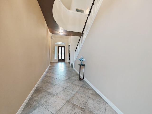 2631 Misty Grove Dr, Manvel, TX 77578 - hall with baseboards, stairs, stone tile flooring, and arched walkways