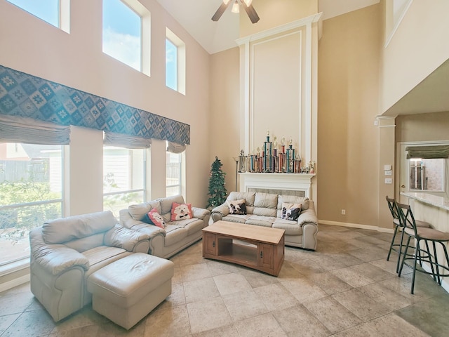 2631 Misty Grove Dr, Manvel, TX 77578 - living room featuring a high ceiling, ceiling fan, stone tile floors, and plenty of natural light