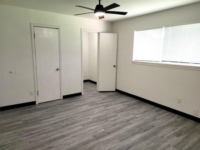 5814 Fontenelle Dr, Houston, TX 77035 - unfurnished bedroom with wood finished floors, baseboards, a ceiling fan, and multiple closets