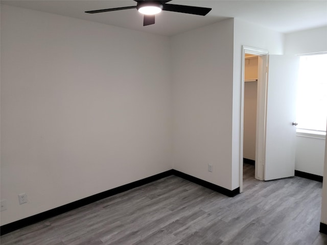 5814 Fontenelle Dr, Houston, TX 77035 - unfurnished bedroom featuring a walk in closet, wood finished floors, multiple windows, and baseboards