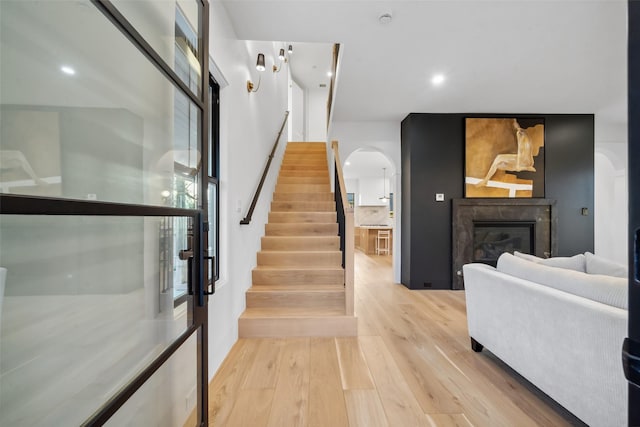 3111 Eastman St, Houston, TX 77022 - stairs featuring arched walkways, wood finished floors, recessed lighting, and a glass covered fireplace