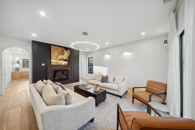 3111 Eastman St, Houston, TX 77022 - living area with arched walkways, light wood-style flooring, recessed lighting, and a glass covered fireplace
