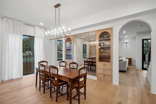 3111 Eastman St, Houston, TX 77022 - dining room with light wood-style flooring, arched walkways, recessed lighting, and a chandelier