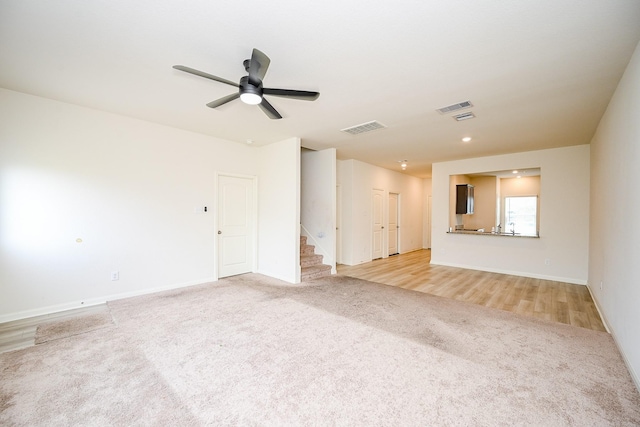 405 Elaine Valley Dr Unit D, Katy, TX 77493 - unfurnished living room with light carpet, stairs, a ceiling fan, baseboards, and recessed lighting
