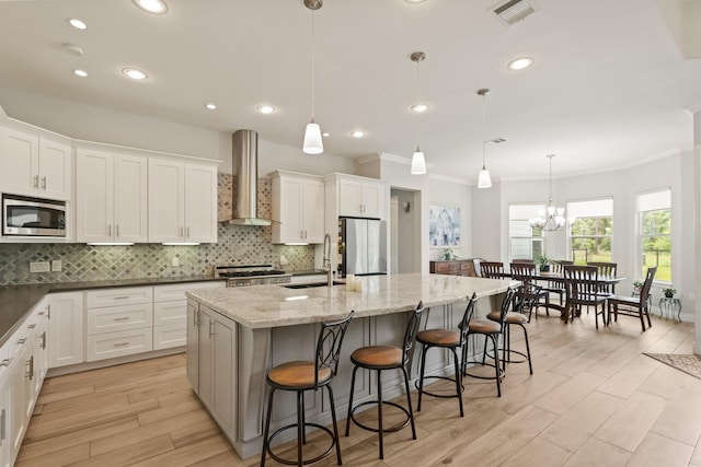 17772 W Terrace Oaks, Waller, TX 77484 - kitchen featuring wall chimney exhaust hood, stainless steel appliances, a sink, a center island with sink, and decorative backsplash