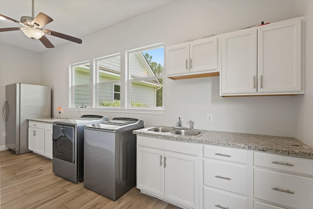 17772 W Terrace Oaks, Waller, TX 77484 - laundry room with washer and clothes dryer, cabinet space, ceiling fan, and light wood-type flooring