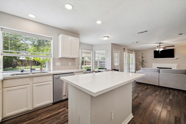 21326 Wildcroft Dr, Katy, TX 77449 - kitchen featuring dishwasher, a sink, dark wood-style floors, a center island, and a fireplace
