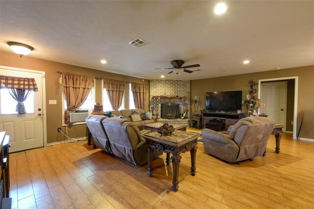 7523 State Highway 21 W, Caldwell, TX 77836 - living room featuring a ceiling fan, light wood-type flooring, cooling unit, recessed lighting, and a brick fireplace