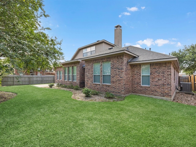 14402 Cottage Timbers Ln, Houston, TX 77044 - rear view of house featuring brick siding, a chimney, central AC, and roof with shingles