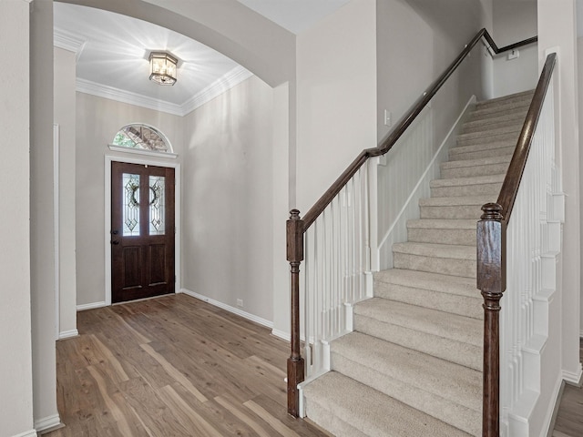 14402 Cottage Timbers Ln, Houston, TX 77044 - foyer entrance with wood finished floors, stairway, baseboards, arched walkways, and crown molding